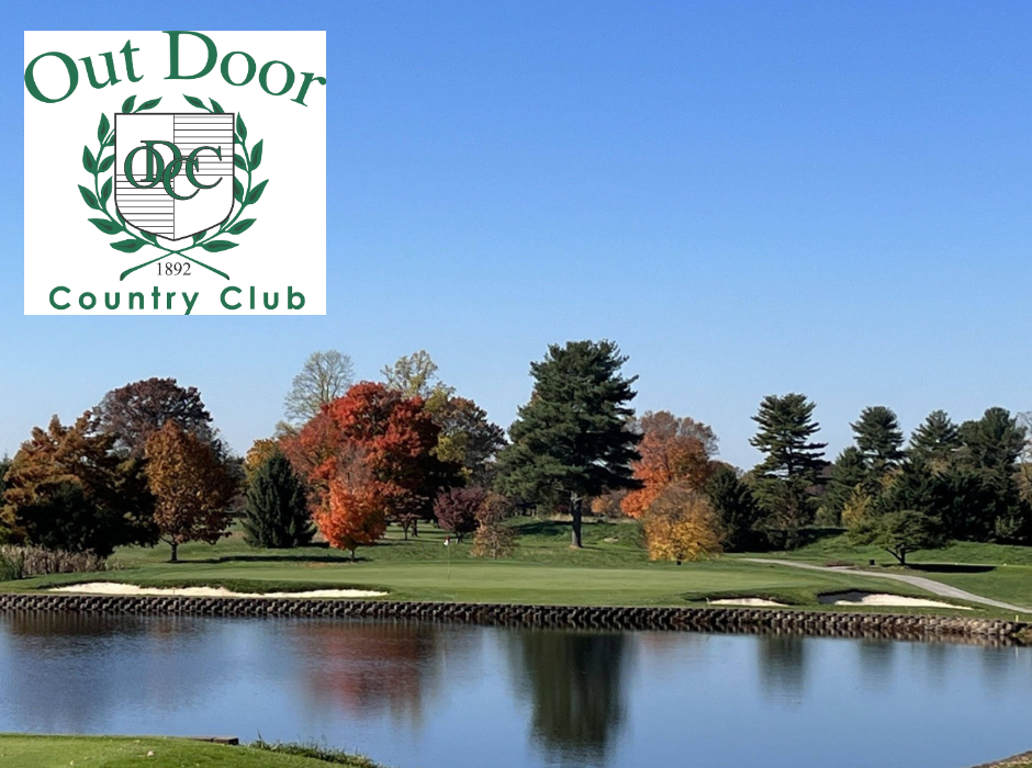 A golf course with trees and water in the background.