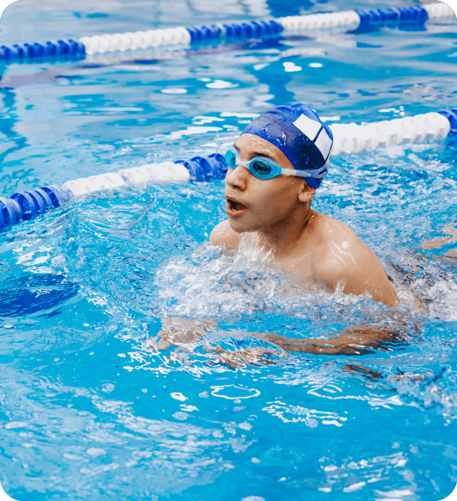 A man swimming in the pool wearing goggles.